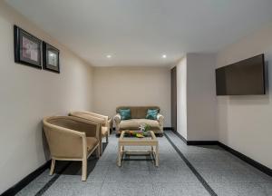 a living room with a couch and chairs and a tv at Greenpark Visakhapatnam in Visakhapatnam
