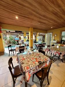 ein Esszimmer mit einem Tisch, Stühlen, Tischen und einem Tisch in der Unterkunft Pousada Porto dos Corais in Maragogi