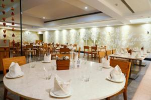 a restaurant with tables and chairs with napkins on them at Greenpark Visakhapatnam in Visakhapatnam