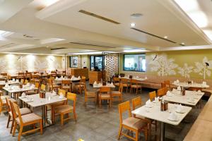 a dining room with white tables and chairs at Greenpark Visakhapatnam in Visakhapatnam