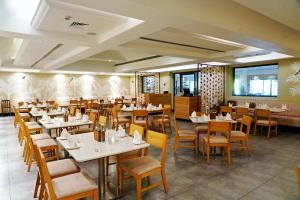 a dining room with tables and chairs and tablesktop at Greenpark Visakhapatnam in Visakhapatnam