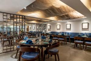 a restaurant with tables and chairs in a room at Greenpark Visakhapatnam in Visakhapatnam