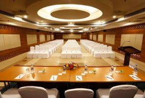 a large room with a large table and white chairs at Greenpark Visakhapatnam in Visakhapatnam