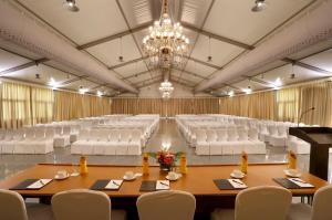 a large room with white chairs and tables and a chandelier at Greenpark Visakhapatnam in Visakhapatnam +24 photos