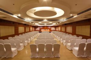a large room with white chairs and a large ceiling at Greenpark Visakhapatnam in Visakhapatnam