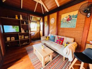 a living room with a couch and a table at Villa Happy Hour in Atiha