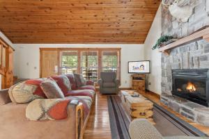 a living room with a couch and a fireplace at Mayberry Lodge Cabin in Branson West