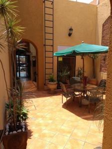 a patio with a table and a green umbrella at Hotel Casa Galena in Morelia +35 photos