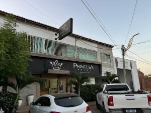 two cars parked in front of a building at PRINCESA HOTEL Russas in Russas