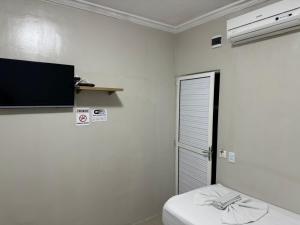 a white room with a bed and a flat screen tv at PRINCESA HOTEL Russas in Russas +3 photos
