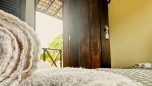a close up of a bedroom with a bed and a door at Pousada Villa Aman in Paraty