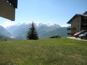 a tree on a hill with mountains in the background at Appartement rénové 2 pièces, 4 couchages, au pied des pistes à Auris - FR-1-297-344 in Auris +2 photos
