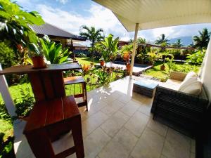 an outdoor patio with a table and an umbrella at TAHITI - Bungalow Toah Toru in Taravao