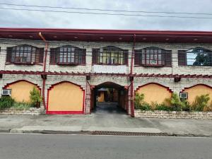 an old brick building with red doors and windows at starlight lodging house in Laoag +4 photos