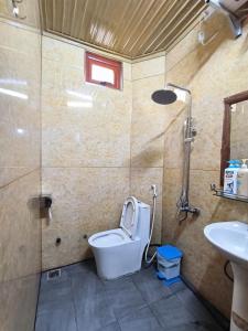 a bathroom with a toilet and a sink at Xúa Vừ Homestay in Mèo Vạc
