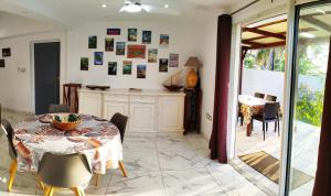 una cucina e una sala da pranzo con tavolo e sedie di Maison Les Cocotiers de Plaiz'Anse a Petite-Île