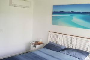 a bedroom with a bed and a painting on the wall at Sand Dunes Resort Stunning Beachfront Apartment in Mudjimba +17 photos