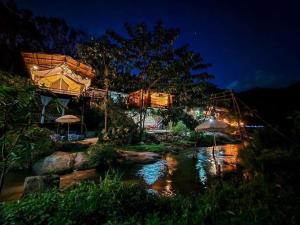 a resort with a water park at night at บ้านชมจันทร์ บ้านสวนสราญชล in Ban Nong Bo