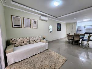 ein Wohnzimmer mit Couch und ein Esszimmer in der Unterkunft Acrópole Residence in Bombinhas