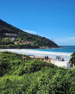 eine Gruppe von Menschen sitzt an einem Strand in der Unterkunft Acrópole Residence in Bombinhas
