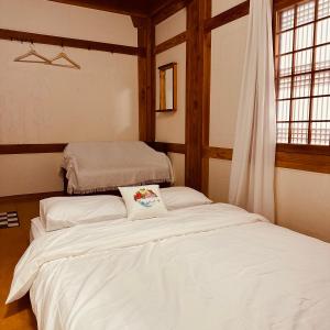 two beds in a room with white sheets at Jeonju Hanok village Deoksugung in Jeonju