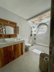 ein Badezimmer mit Toilette, Waschbecken und Spiegel in der Unterkunft Casa Mystic Boutique villa in Gili Air + 18 Fotos