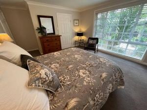 a bedroom with a large bed and a window at The Cricket House - Family & Pet-Friendly Home in Bowral