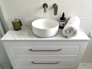 a bathroom counter with a sink and a towel at The Cricket House - Family & Pet-Friendly Home in Bowral +16 photos