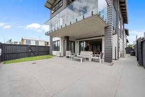 patio con sedie e tavolo sul lato di una casa di Beachfront Paradise - Papamoa Beach Holiday Home a Papamoa