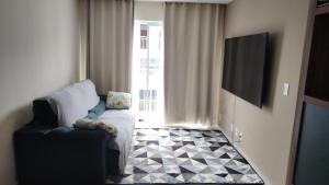 a living room with a couch and a television at Espaço ling in João Pessoa