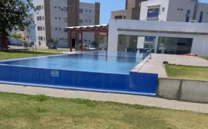 a large blue swimming pool in front of a building at Espaço ling in João Pessoa