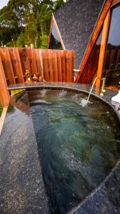 a pool of water in a backyard with a wooden fence at Chalé Boutique Spa- Sauna seca, Jacuzzi , Rede suspensa in Campos do Jordão