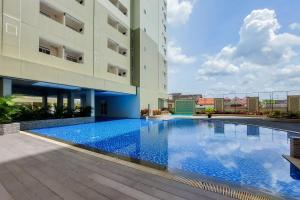 a swimming pool in front of a building at Comfort Stay 2BR at Loftvilles City Apartment By Travelio in Tangerang