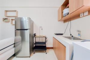 a kitchen with a stainless steel refrigerator next to a sink at Comfort Stay 2BR at Loftvilles City Apartment By Travelio in Tangerang