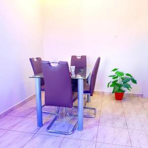 a table with purple chairs and a laptop on it at Appart cosi 1 chambre centre ville in Atchati