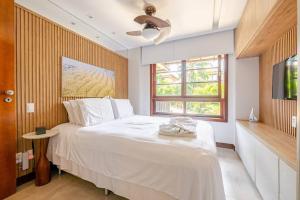 a bedroom with a large white bed and a window at PRAIA DO FORTE CONDOMINIO KAUAI in Praia do Forte +37 photos