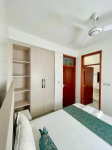 a bedroom with a large bed and a red door at Buxton point apartment in Mombasa +71 photos