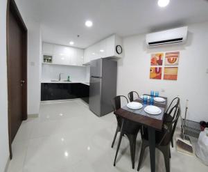 a kitchen and dining room with a table and chairs at Near Ferry Terminal - Lovely 2 Bedroom Condo - Harbourbay Residences - 0608 in Tanjunguma