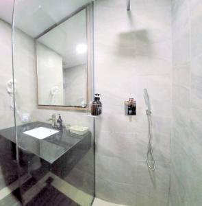 a bathroom with a glass shower and a sink at Near Ferry Terminal - Lovely 2 Bedroom Condo - Harbourbay Residences - 0608 in Tanjunguma