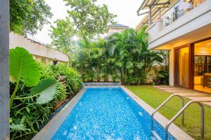 a swimming pool in the backyard of a house at ELIVAAS 4 BHK with Pvt & Outdoor Sitting Area - Anasa in Goa