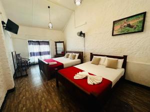 a hotel room with two beds and a red couch at Green view Kandy in Kandy