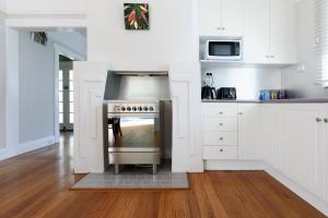a kitchen with a stainless steel stove and white cabinets at The Basin Cottage in Royal Park
