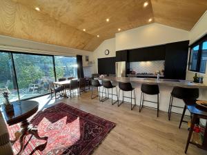 a kitchen and living room with a counter and chairs at Pedal and Play - Cromwell Holiday Home in Cromwell