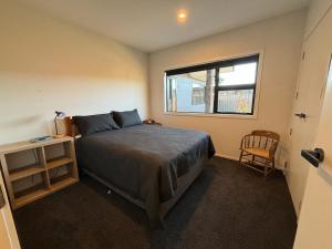 a bedroom with a large bed and a window at Pedal and Play - Cromwell Holiday Home in Cromwell