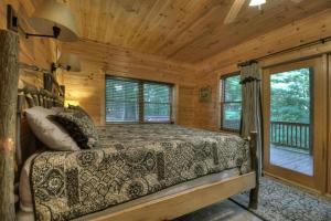 ein Schlafzimmer mit einem Bett in einer Blockhütte in der Unterkunft The Retreat in Blue Ridge