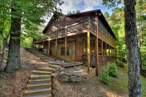 eine Blockhütte im Wald mit einer Treppe, die hinauf führt in der Unterkunft The Retreat in Blue Ridge
