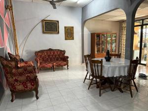 a living room with a table and chairs at HOMESTAY Sg Petani in Sungai Petani