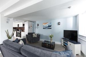 Una sala de estar con un sofá y un televisor. en Offshore, Carbis Bay, St Ives, en Carbis Bay