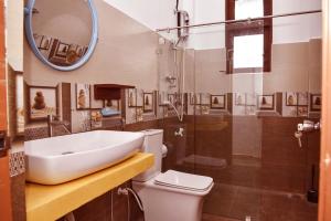 a bathroom with a sink and a toilet and a mirror at Travel Neth Holidays Bungalow Anuradhapuraya in Anuradhapura