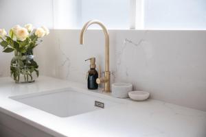 a kitchen counter with a sink and a vase of flowers at 201 Cascades l 2 Bed Boutique Aparthotel in Cape Town +19 photos